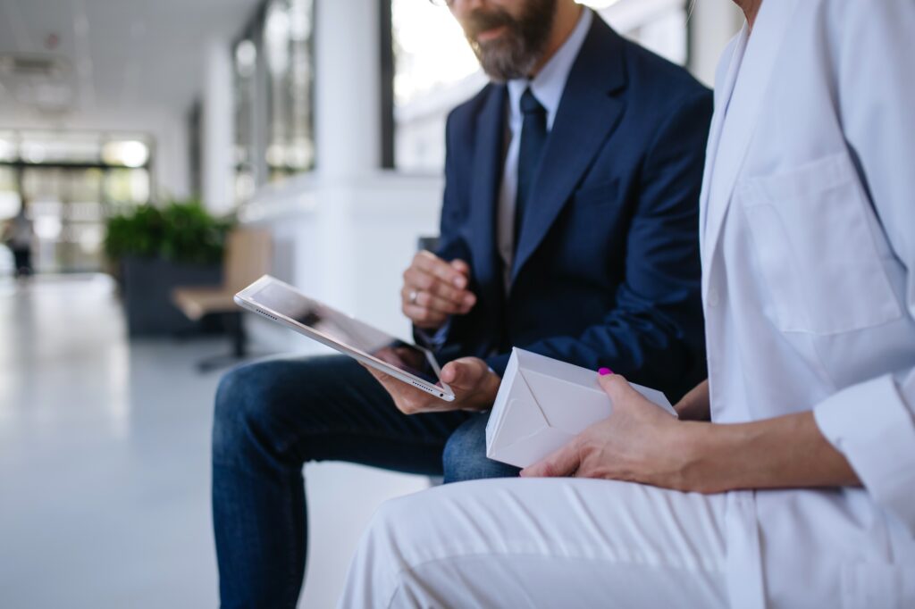 Close up of pharmaceutical sales representative talking with female doctor in medical building